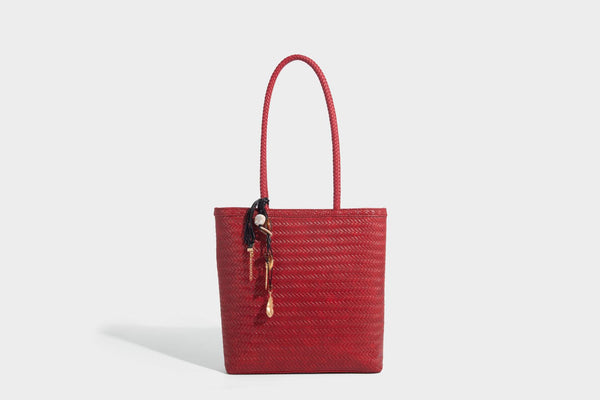 Structured woven herringbone tote bag with braided double shoulder handles in tan brown, shown with matching drawstring