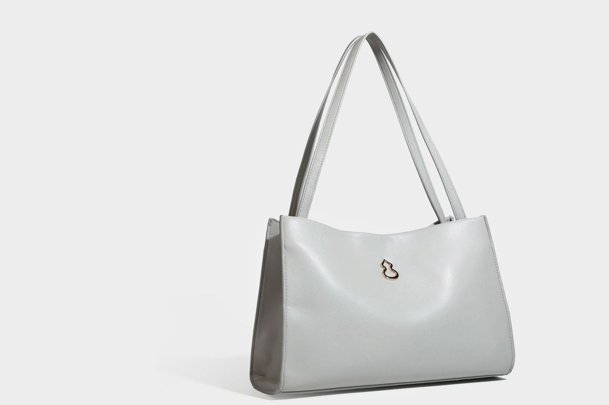 Structured rectangular shoulder tote bag with smooth leather-look finish, long double straps, and gold-tone gourd emblem on