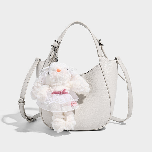 Small pebbled half-moon shoulder bag with dual top handles, detachable crossbody strap, and silver-tone hardware, detail view