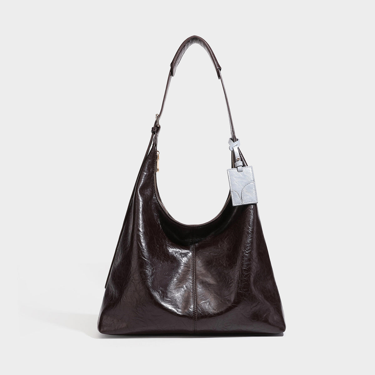 Große dunkelbraune, glänzende Hobo-Schultertasche mit Crinkle-Optik, Reißverschluss, goldfarbenen Metalldetails, verstellbarem Riemen und Hellblau