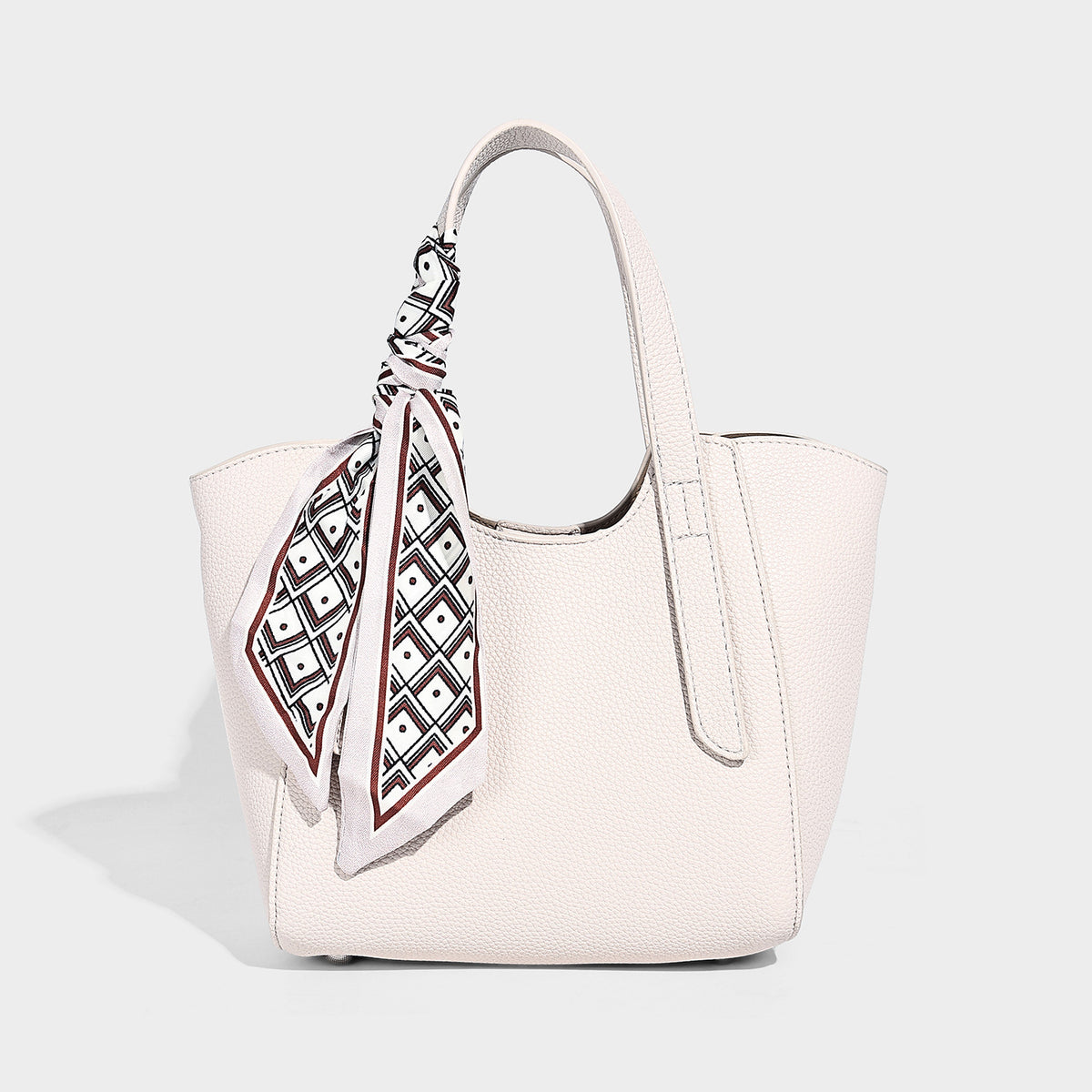 Structured pebbled leather-look tote bag with detachable scarf tie, dual top handles, and adjustable crossbody strap, detail