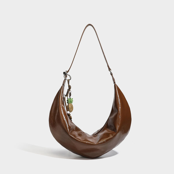 Lässige sichelförmige Hobo-Schultertasche aus glänzender, geknautschter Lederoptik mit schmalem Riemen, silberfarbenem Ringbeschlag und