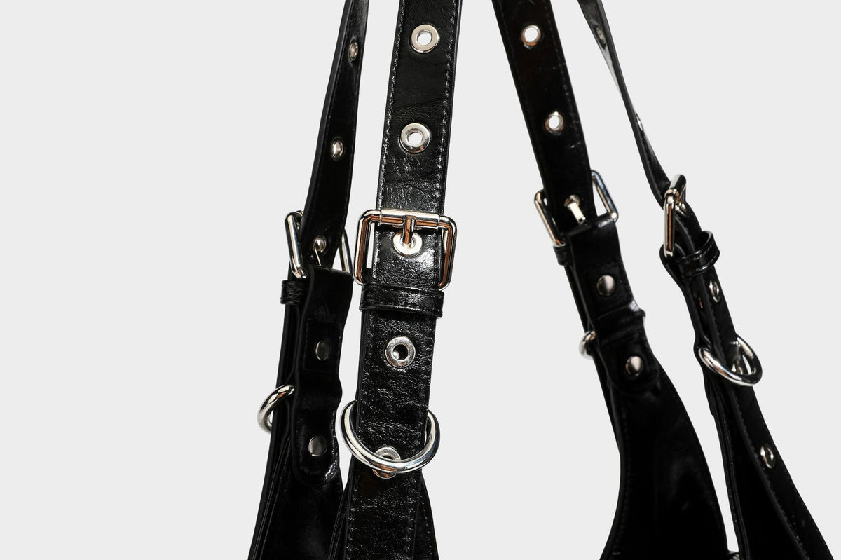 Große glänzende schwarze Hobo-Schultertasche mit silberfarbenem Ösen-Gürtelboden, Schnallenbeschlägen, vorderer Reißverschlusstasche und zwei …; Detailansicht
