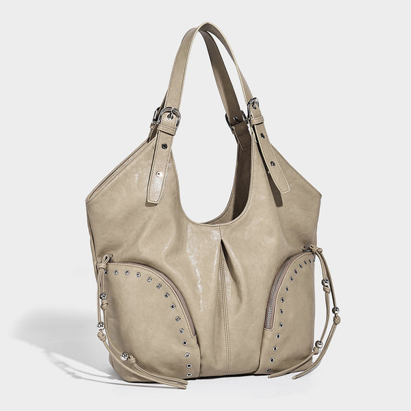 Große lässig-geschwungene Hobo-Schultertasche in Kunstlederoptik mit silberfarbenen Nieten, mit Ösen eingefassten Reißverschlusstaschen auf der Vorderseite und verstellbaren doppelten