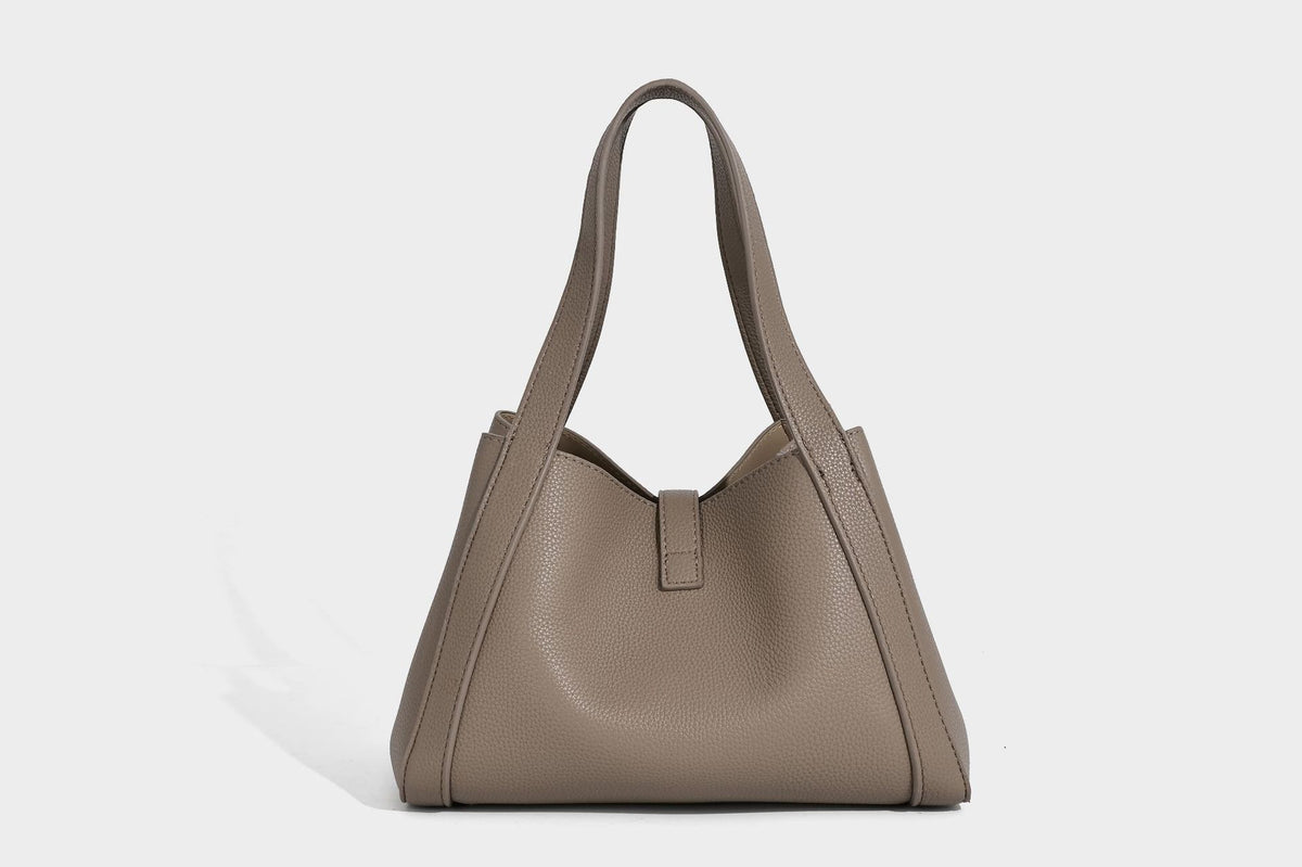 Structured trapezoid tote bag in taupe pebbled leather-look finish with gold-tone turn-lock hardware, dual top handles, and