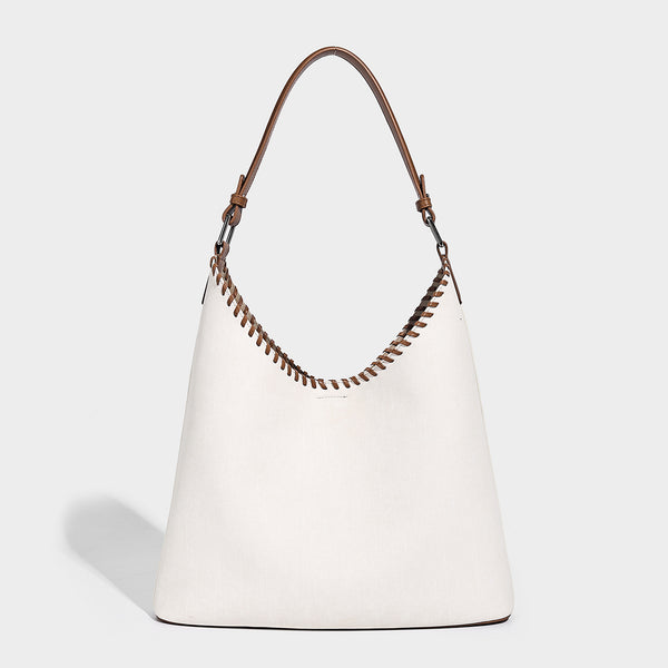 Denim-blue hobo tote with white leather-look shoulder strap, contrast whipstitch trim along curved open top, and silver-tone