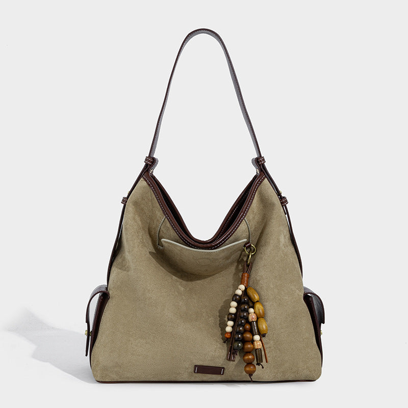 Weich fallende Hobo-Schultertasche in Khaki mit matter Velourslederoptik, Besatz in dunkelbrauner Lederoptik, Quastenanhänger mit Perlen und seitlicher Klappe, Detailansicht