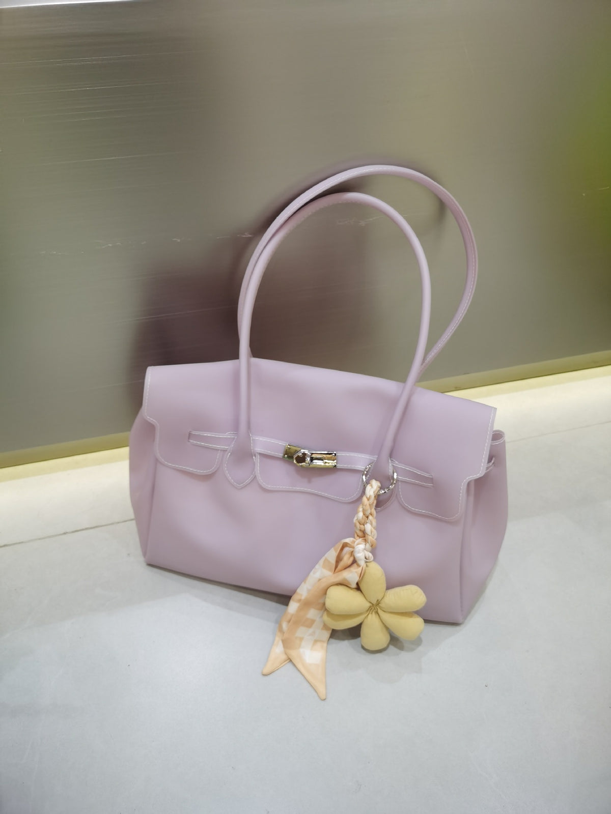 Strukturierte Tote-Bag aus mattem Jelly-Material mit goldfarbenem Klappverschluss mit Drehverschluss, zwei Schulterhenkeln, seitlichen Zwickeln und dekorativer