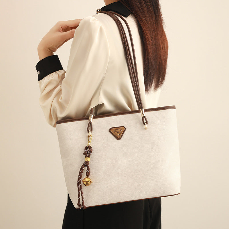 Großer strukturierter Shopper mit offenem Oberteil in Creme mit dunkelbraunen Besätzen in Lederoptik, zwei Schulterriemen und dreieckigem Logo-Badge
