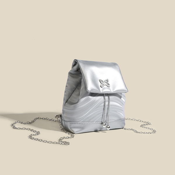 Compact ripple-embossed leather-look backpack handbag with silver butterfly clasp and chain straps, detail view 3