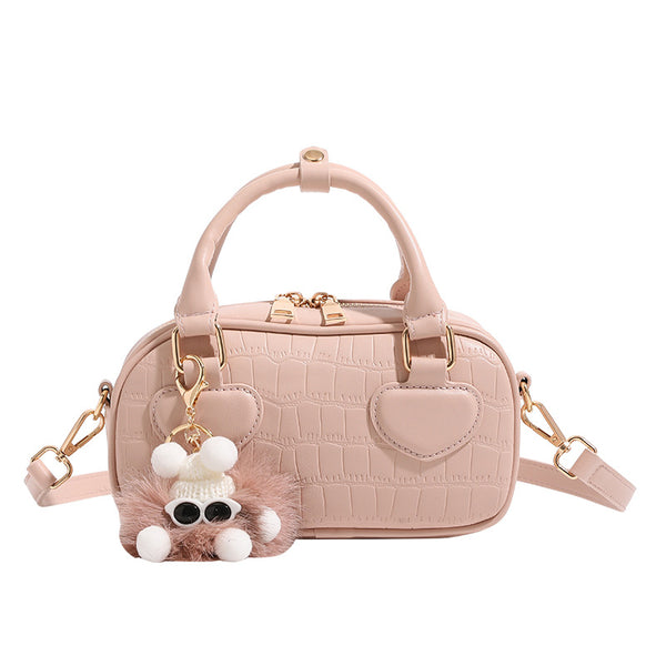 Mini croc-embossed barrel handbag with gold-tone hardware, dual zip top handles, detachable crossbody strap, and fluffy
