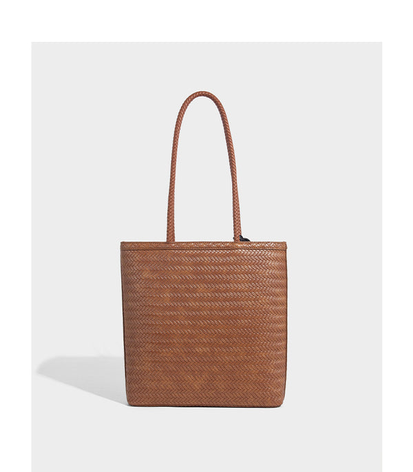 Structured woven herringbone tote bag with braided double shoulder handles in tan brown, shown with matching drawstring