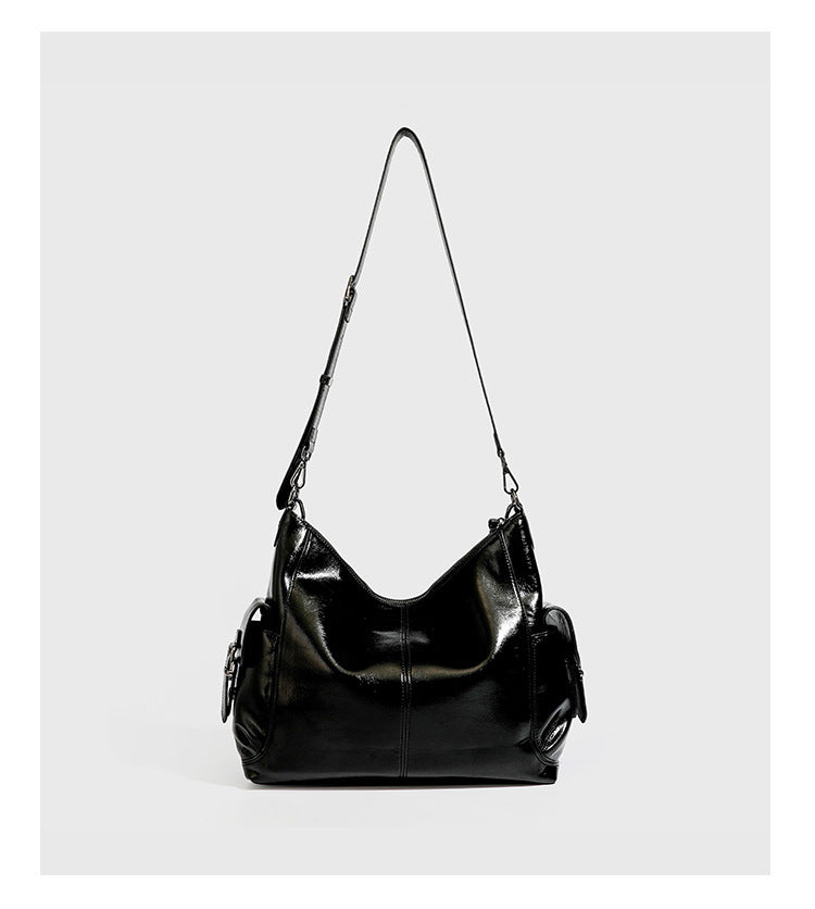 Slouchy hobo shoulder bag with glossy leather-look finish, silver-tone chain drape across front, side buckle pockets, and