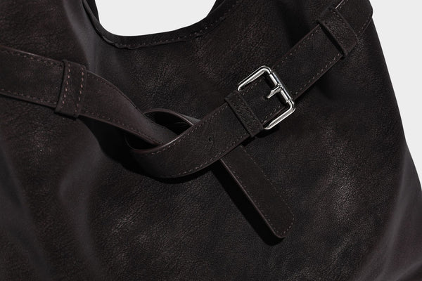 Slouchy oversized shoulder tote bag with matte textured finish, wrap-around buckle strap, and detachable front zip pouch