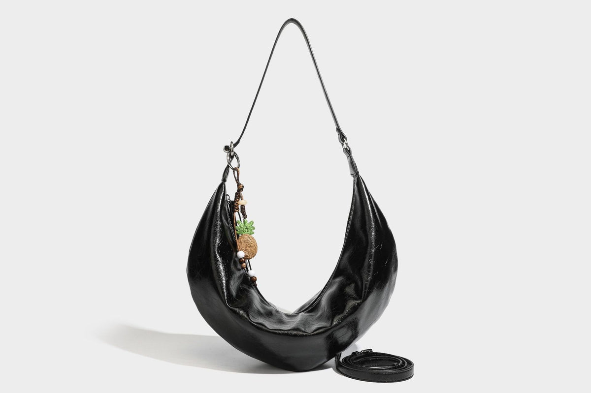 Lässig fallende Hobo-Schultertasche in Halbmondform mit glänzender, geknautschter Lederoptik, schmalem Riemen, silberfarbenen Ringbeschlägen und