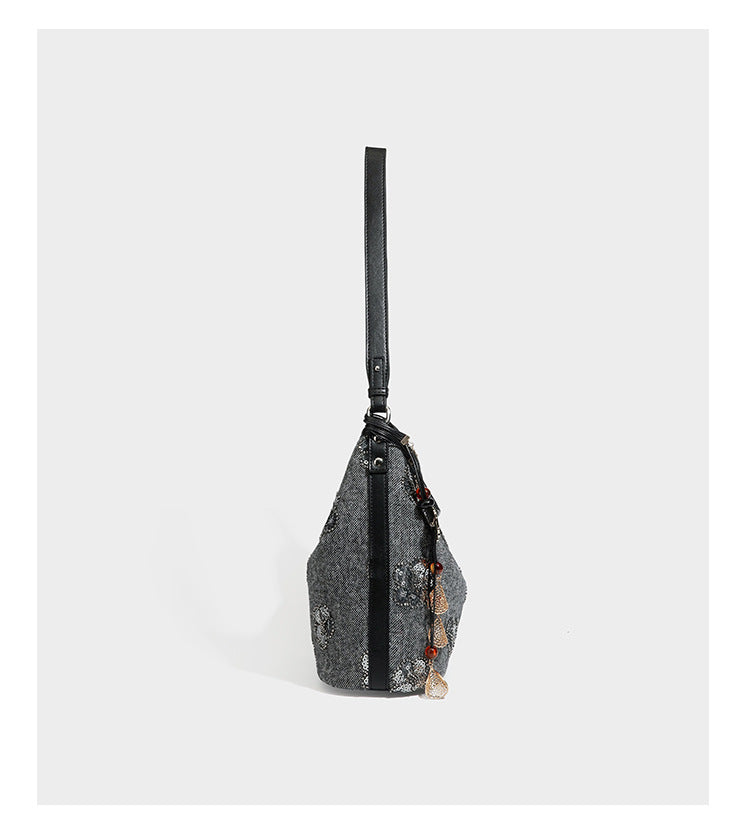 Lässig fallende Hobo-Schultertasche aus anthrazitfarbenem Webstoff mit floraler Stickerei aus silberfarbenen Pailletten, schwarzem Besatz in Lederoptik und langem