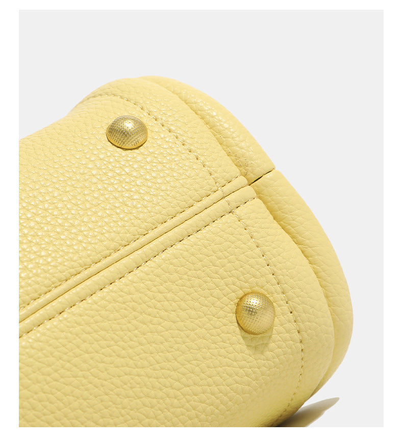 Small structured pebbled leather-look bucket tote bag with bow charm tie closure and gold-tone hardware, detail view 16