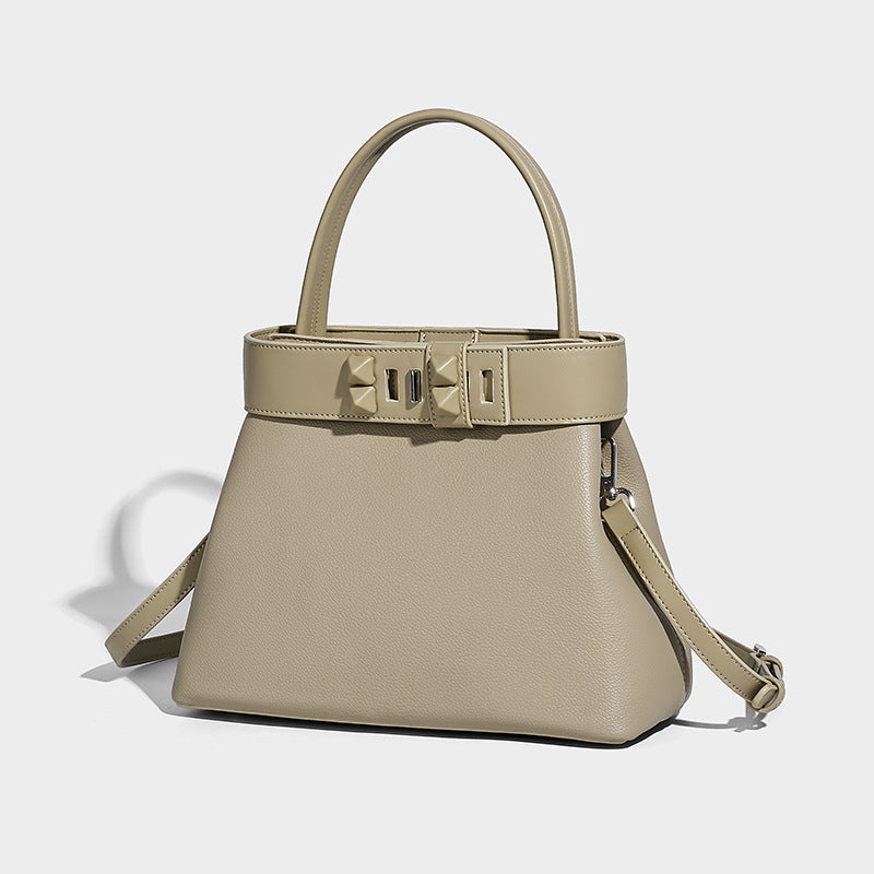 Structured trapezoid tote bag with belt-buckle top band, pebbled leather-look finish, and silver-tone hardware, front view