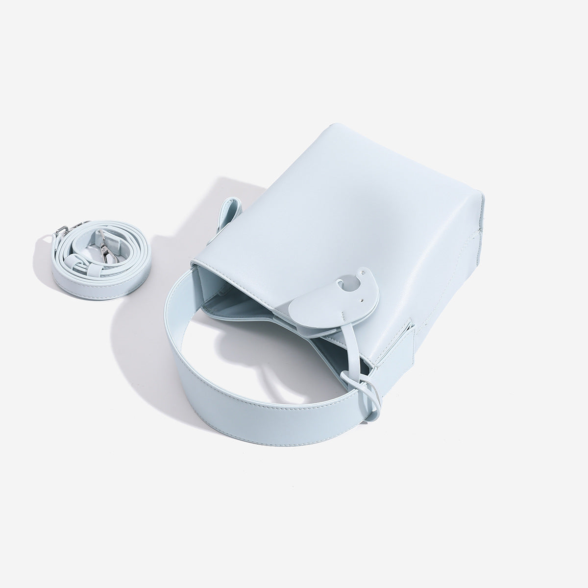 Mini-Bucket-Tasche mit strukturierter Form aus glatter, matter eisblauer Lederoptik, gewölbtem Tragegriff und abnehmbarem Crossbody-Riemen