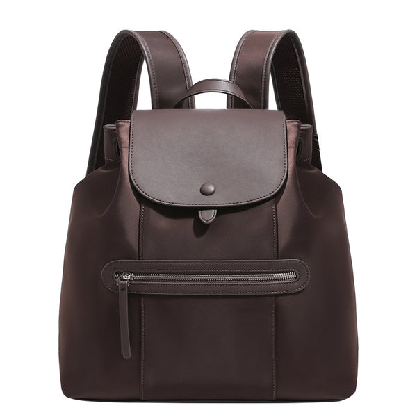 Large flap-top nylon backpack with leather-look trim, snap closure, front zip pocket, and padded shoulder straps, detail view