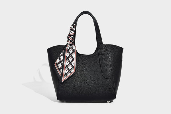 Structured pebbled leather-look tote bag with detachable scarf tie, dual top handles, and adjustable crossbody strap, detail