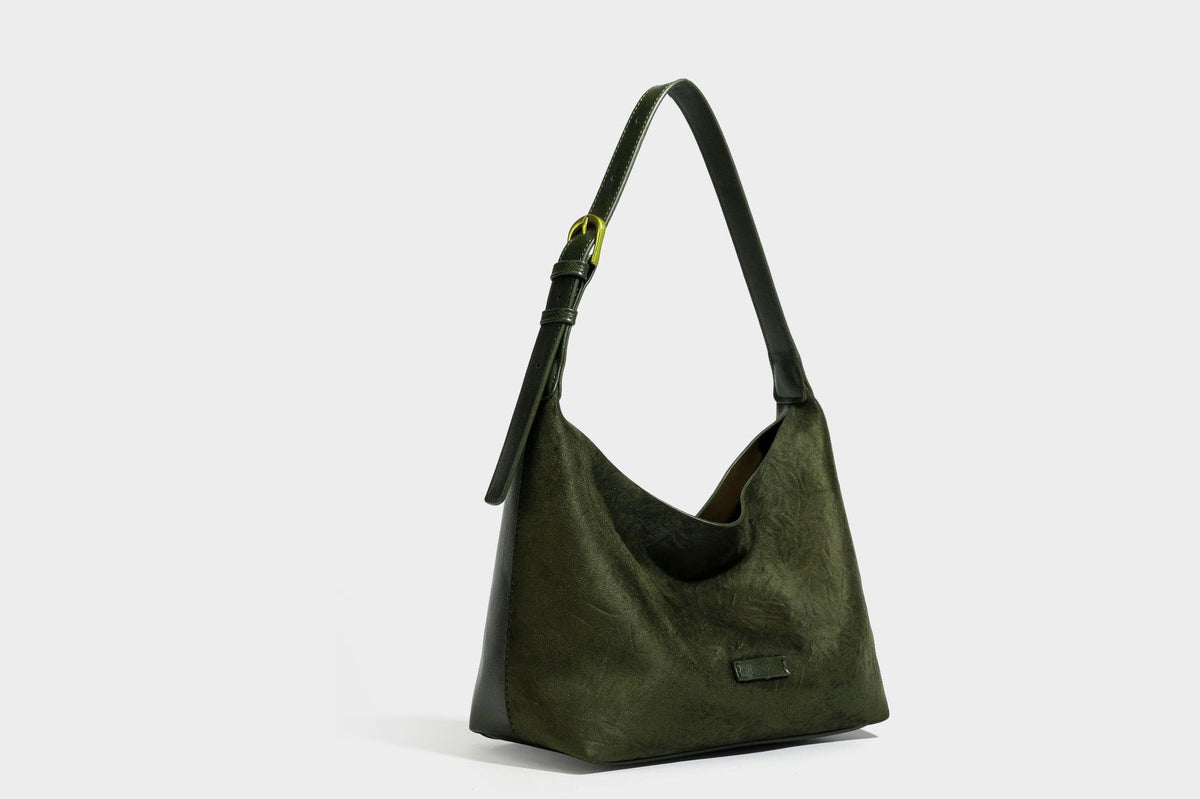 Dunkelbraune, lässig fallende Hobo-Schultertasche mit velourslederähnlich strukturierter Oberfläche, glatter lederähnlicher Paspelierung und Details in Antikgoldoptik, Detailansicht