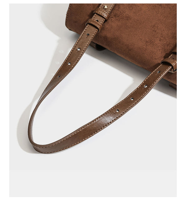 Structured suede-look convertible backpack handbag with flap closure and gold-tone emblem hardware in chocolate brown, detail