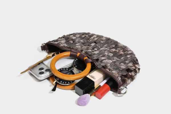 Small sequin half-moon handbag with circular wood-look ring handles and detachable leather-look shoulder strap, detail view