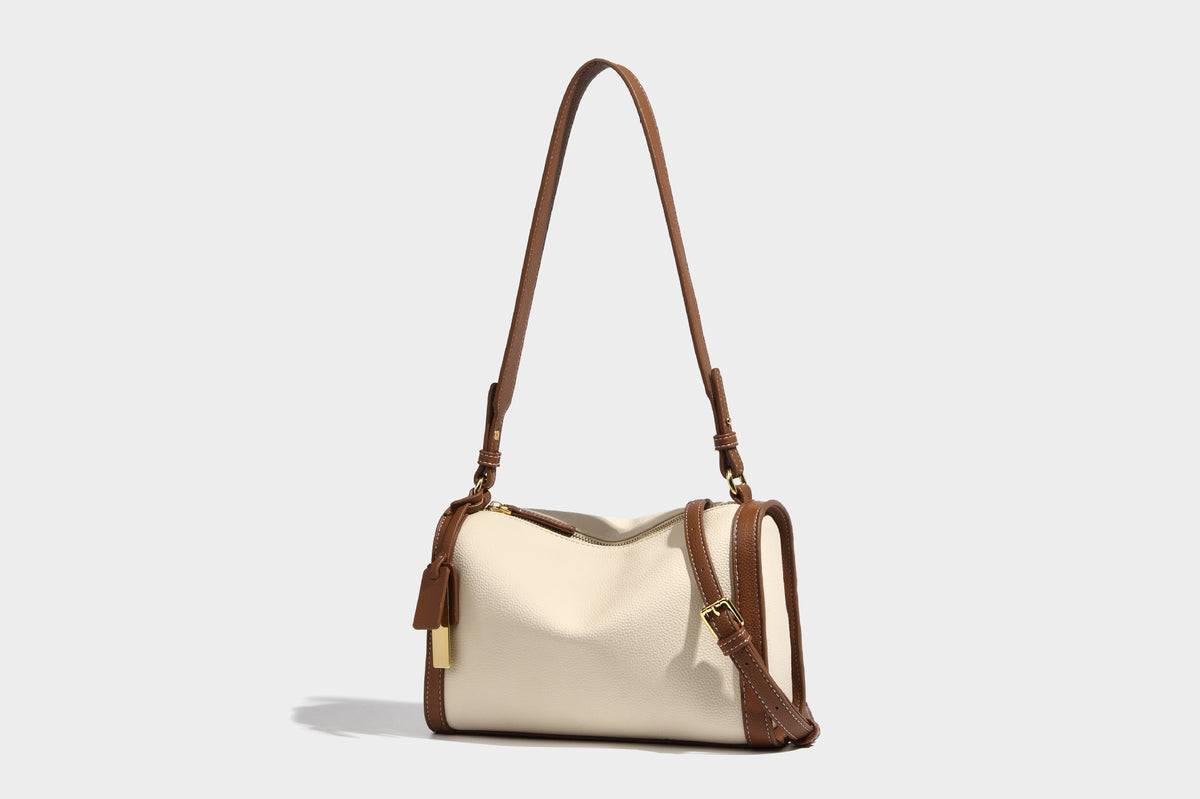Structured two-tone shoulder bag with pebbled leather-look finish, contrast trim, top zip closure, and gold-tone hardware