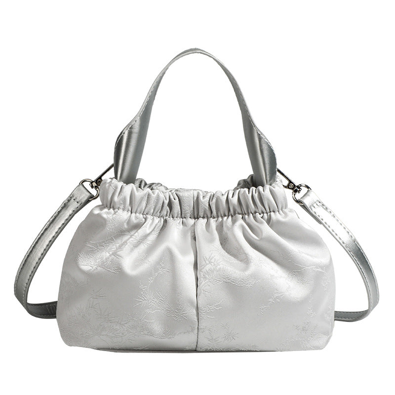 Small ruched satin-finish cloud bag with elasticized drawstring top, short top handle, and chunky silver-tone chain strap
