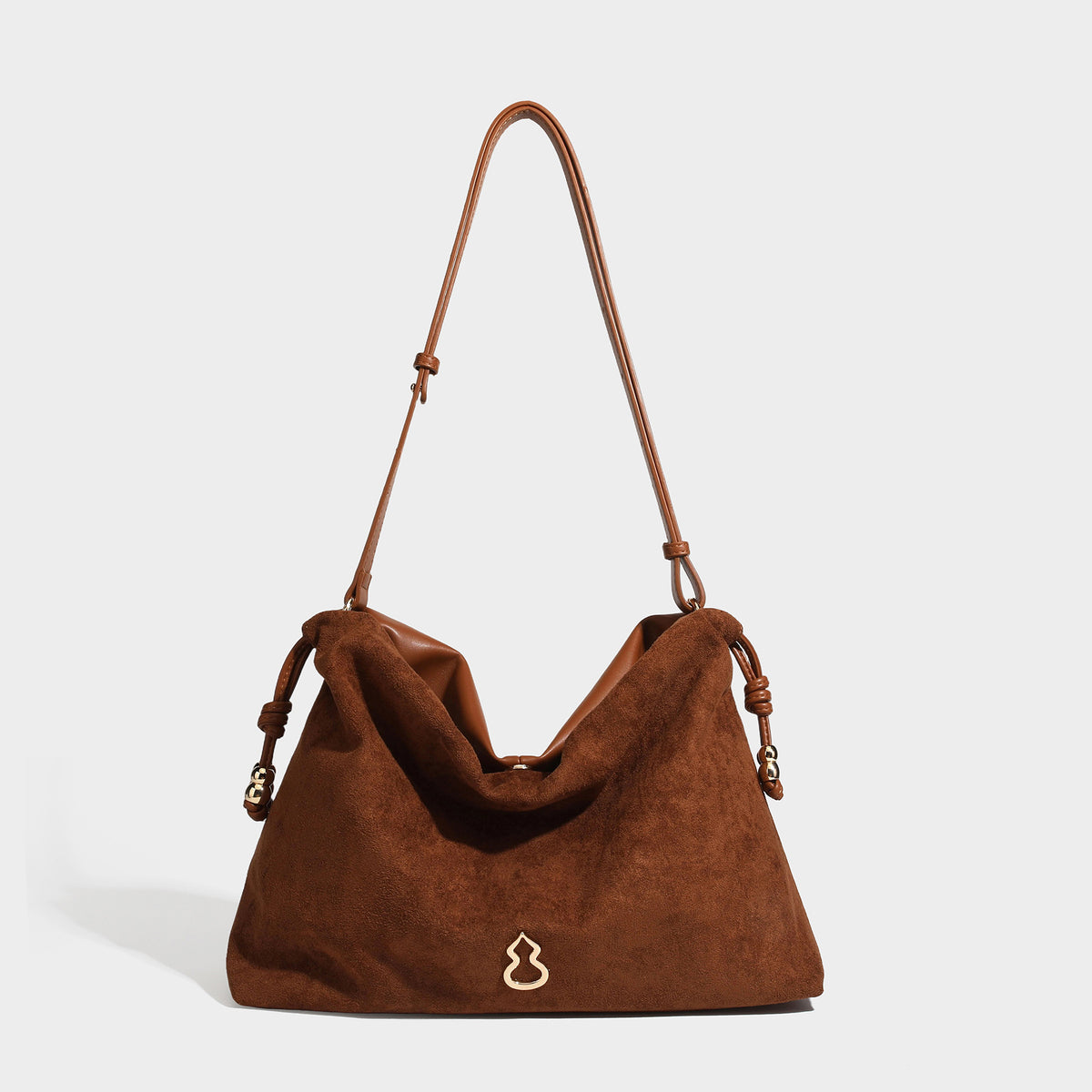 Suede-look drawstring shoulder bag in brown with smooth trim, knotted bead drawstring closure, slim adjustable strap, and