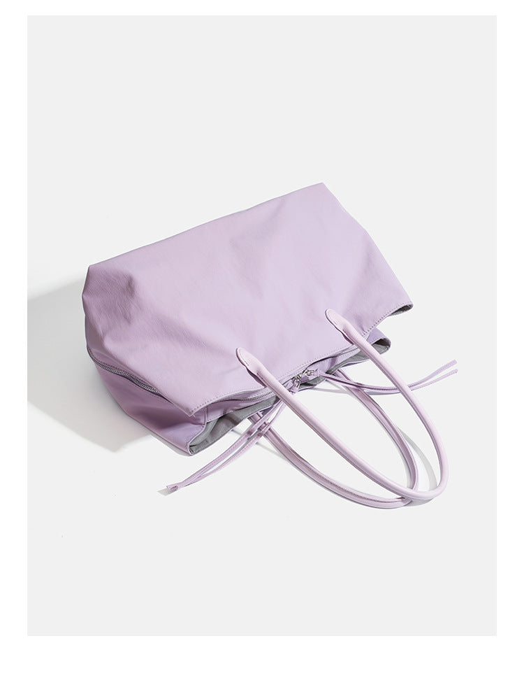 Large soft nylon tote bag with long double handles and zippered top in lavender, detail view 8