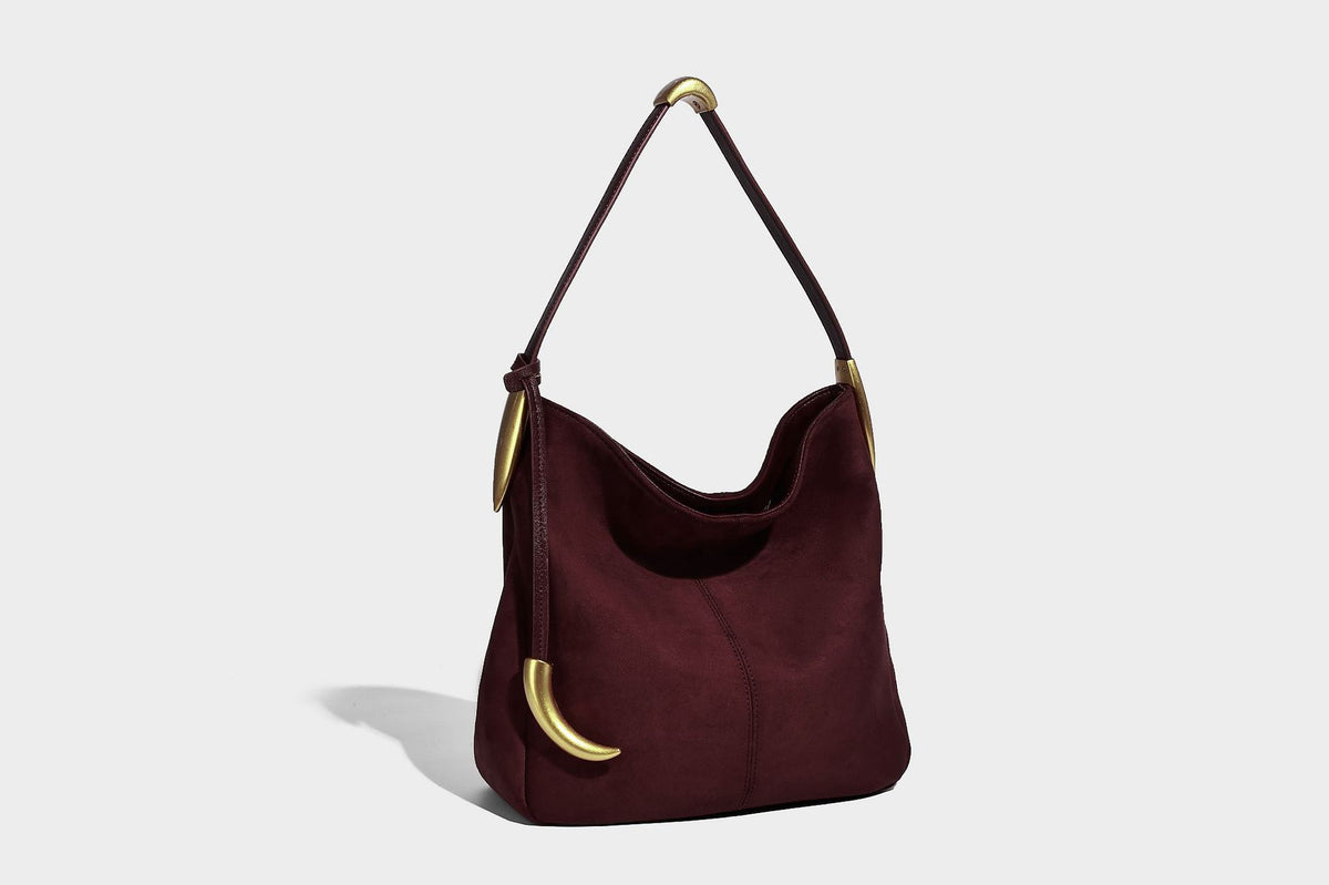 Beige-braune Hobo-Schultertasche mit lässiger Silhouette, matter Veloursleder-Optik, goldfarbenen halbmondförmigen Beschlägen und schmalem Schulterriemen, Detailaufnahme