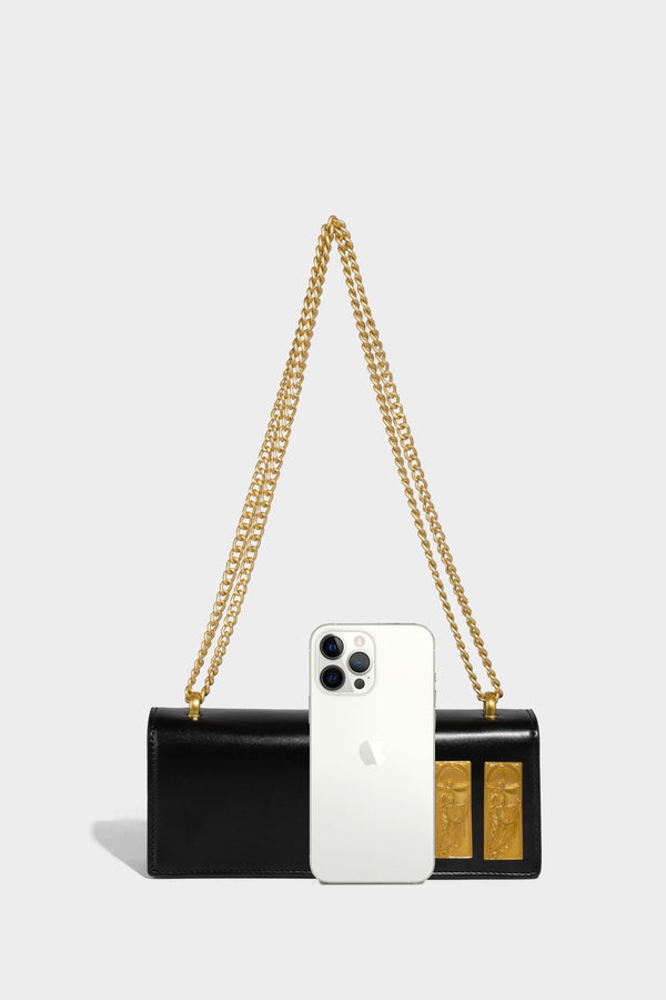 Structured rectangular crossbody bag with glossy finish, three vertical gold-tone embossed plaques, and gold chain strap