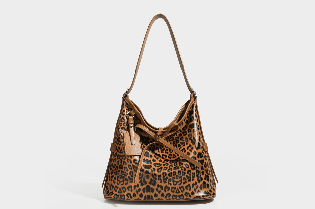 Slouchy leopard print shoulder hobo bag with black leather-look trim, tie-top closure, and single long strap, detail view 25