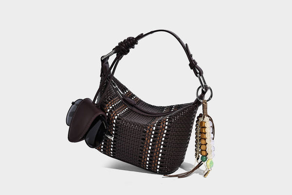 Small woven crescent shoulder bag with leather-look trim, zip closure, silver-tone ring hardware, and beaded tassel charm