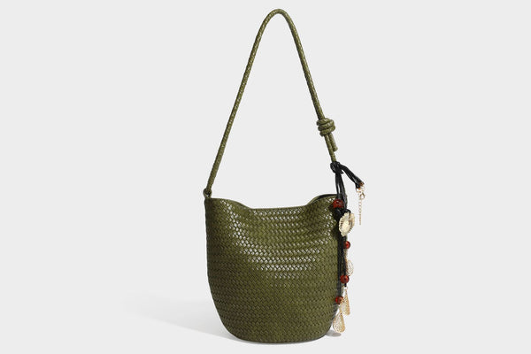 Olive green woven leather-look bucket bag with braided crossbody strap, knotted adjustment, and gold-tone tassel charm with