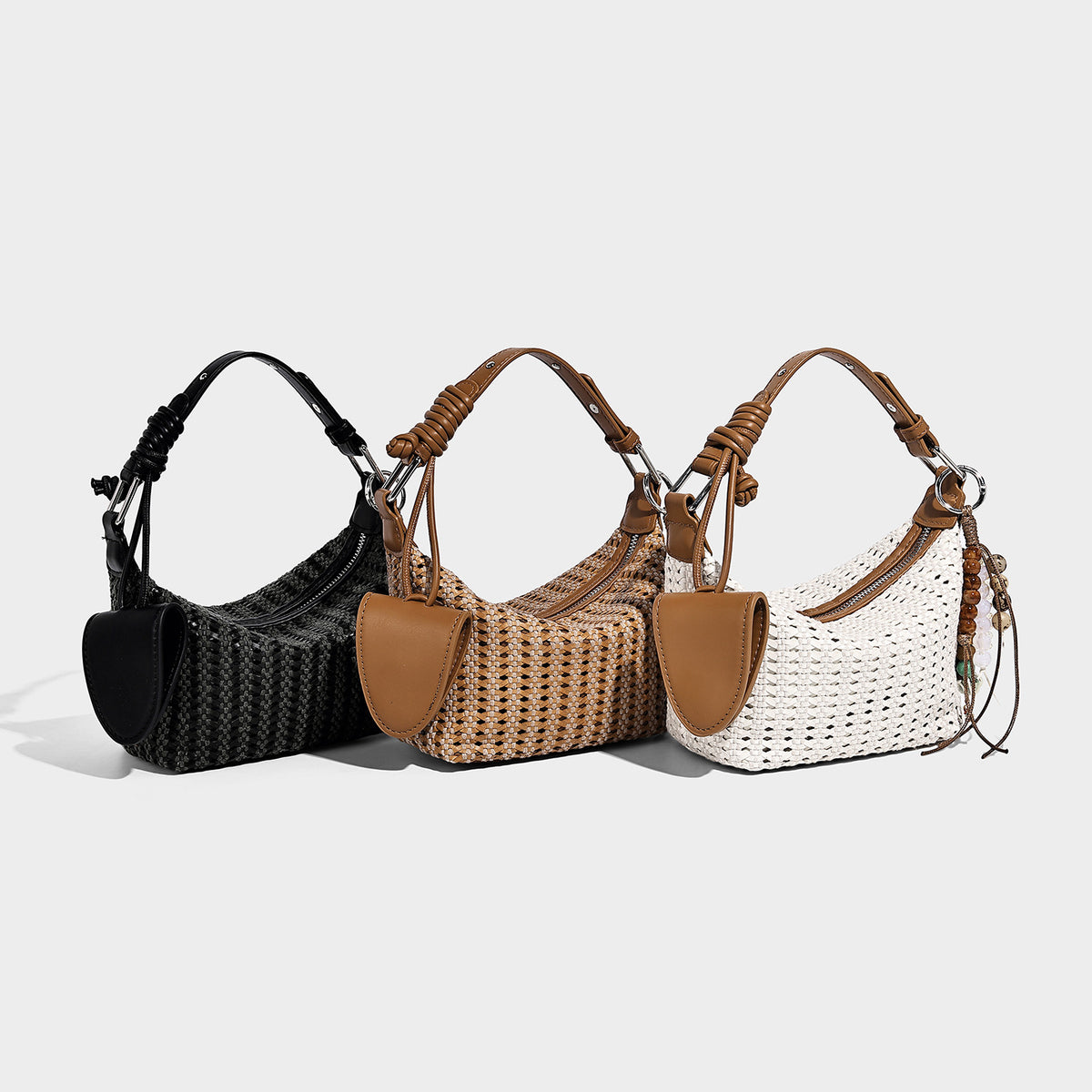 Woven crescent shoulder bag with leather-look knotted handle, zip top, attached mini pouch, and silver-tone hardware, detail