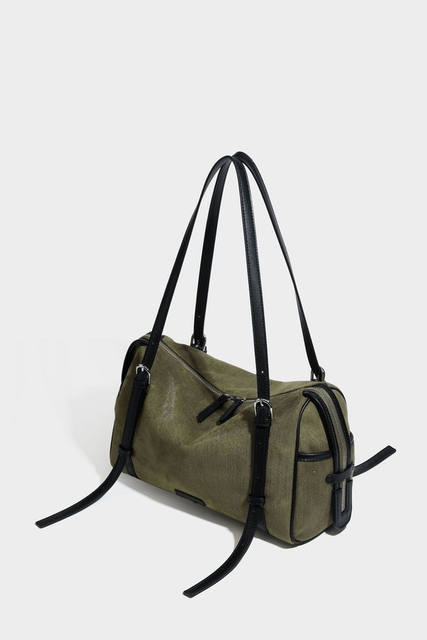 Olivgrüne Canvas-Schultertasche in Zylinderform mit schwarzen Trägern in Lederoptik, Reißverschluss oben und silberfarbenen Metallbeschlägen, Detailansicht
