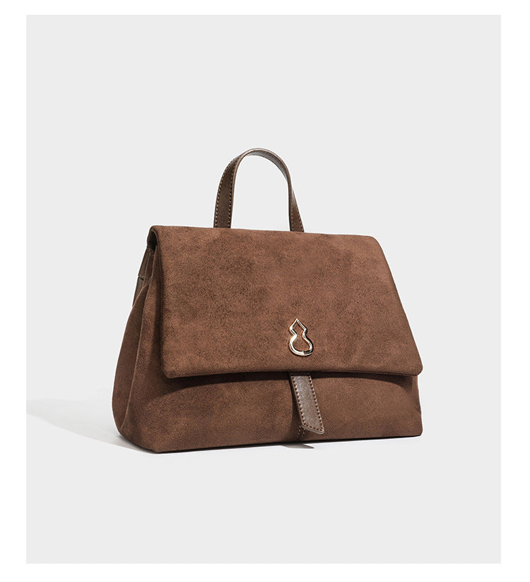 Formstabile Satchel-Tasche mit Überschlag in matter Veloursleder-Optik, goldfarbenen Emblem-Details, kurzem Tragegriff und verstellbarem Crossbody-Riemen