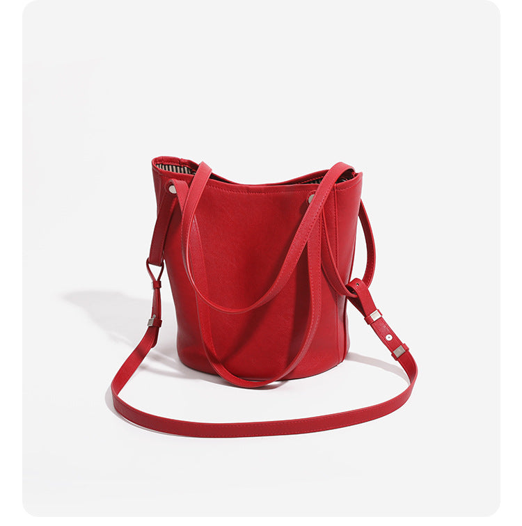 Large leather-look bucket tote bag with dual top handles and adjustable crossbody strap, detail view 17