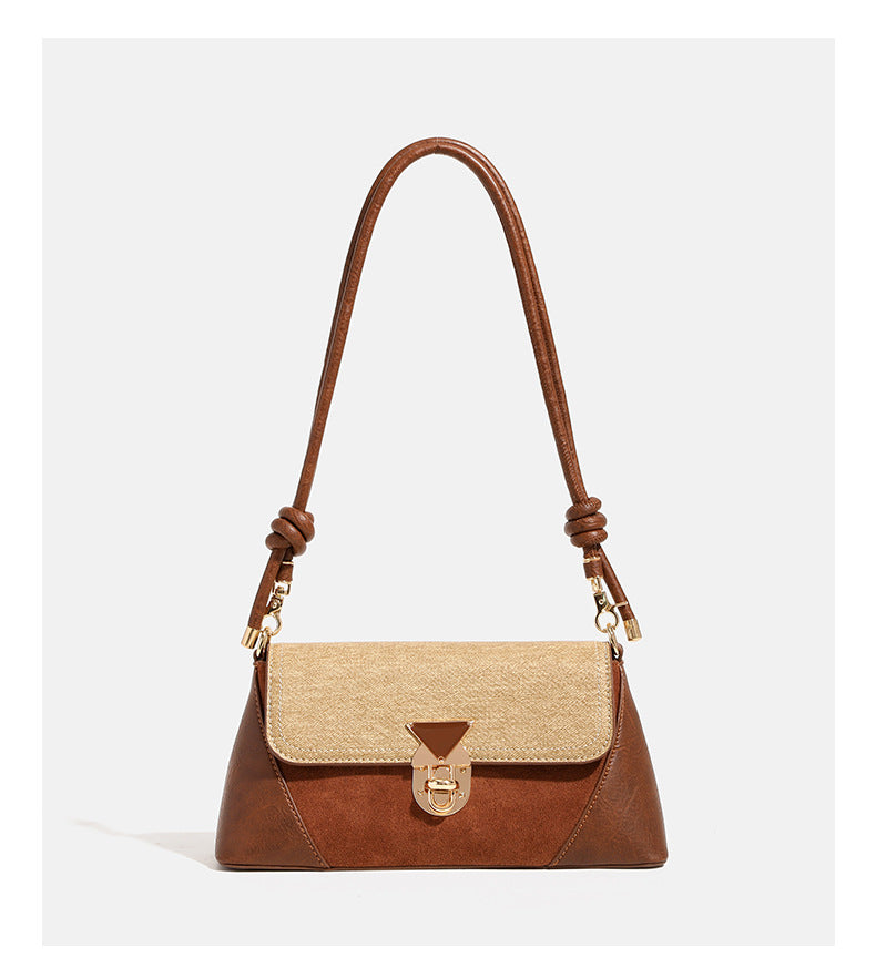 Structured trapezoid shoulder bag with pale textured flap, gold-tone triangular turn-lock closure, and long knotted cord