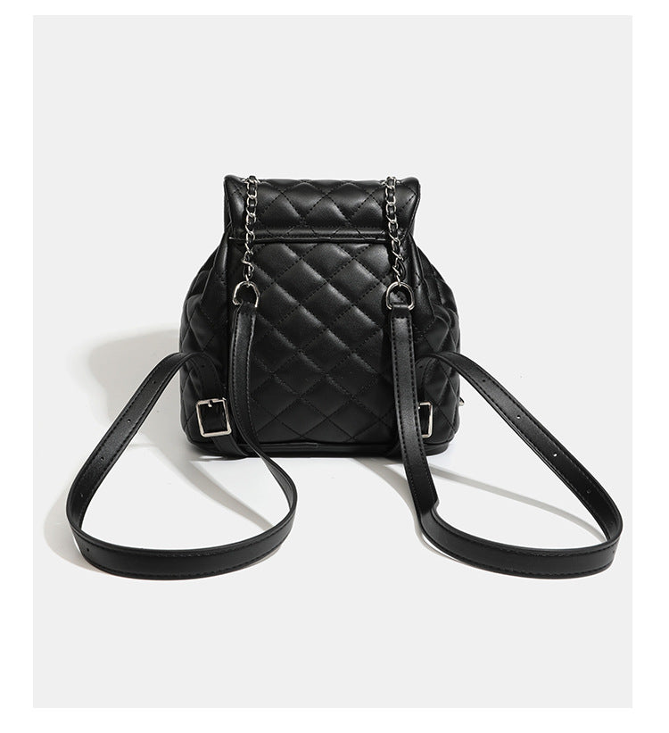 Black diamond-quilted backpack handbag with silver-tone chain flap accent and adjustable shoulder straps, detail view 14