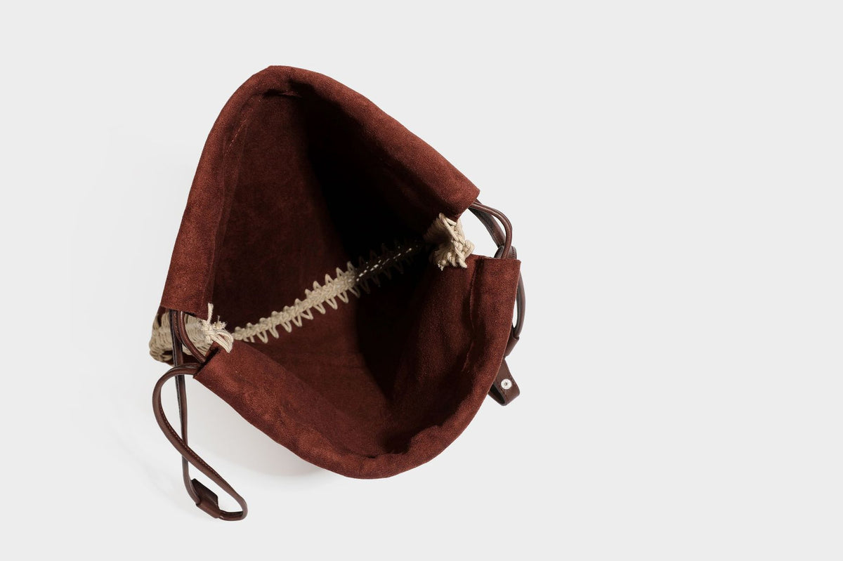 Matte suede-look drawstring bucket bag with cream braided woven edge trim and slim adjustable leather-look shoulder strap