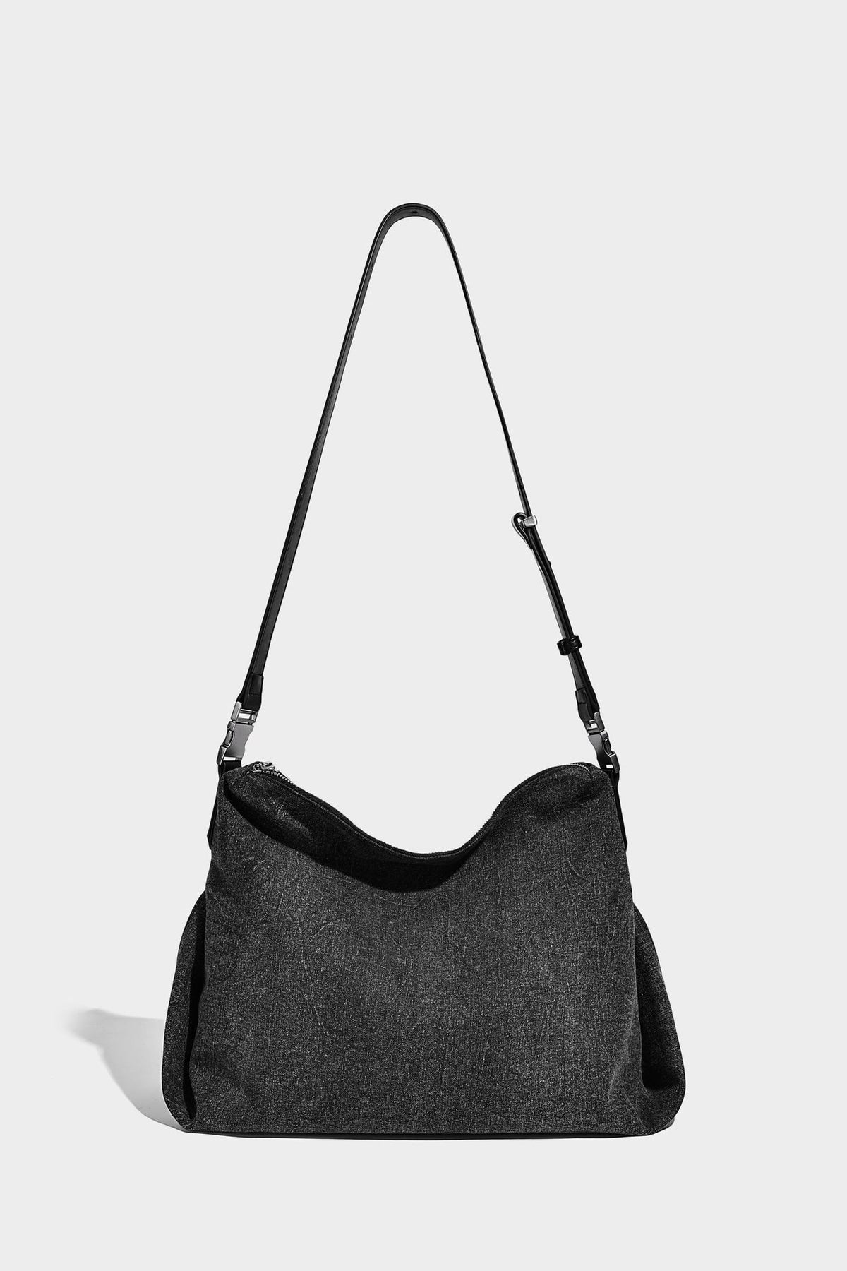 Charcoal denim-textured slouchy hobo bag with zip-top closure, silver-tone hardware, and adjustable leather-look crossbody
