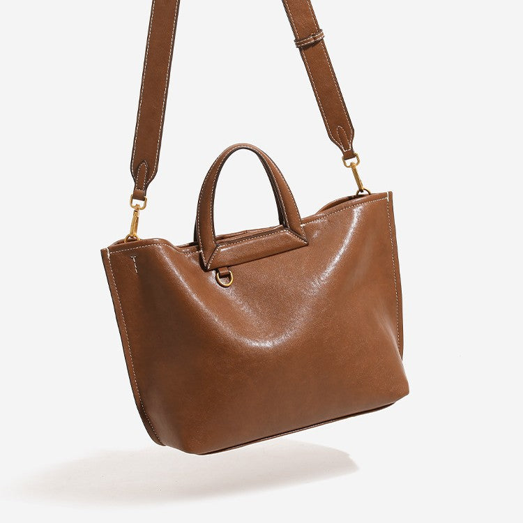 Structured cognac brown leather-look tote bag with fold-ear side panels, top handles, gold-tone hardware, and detachable