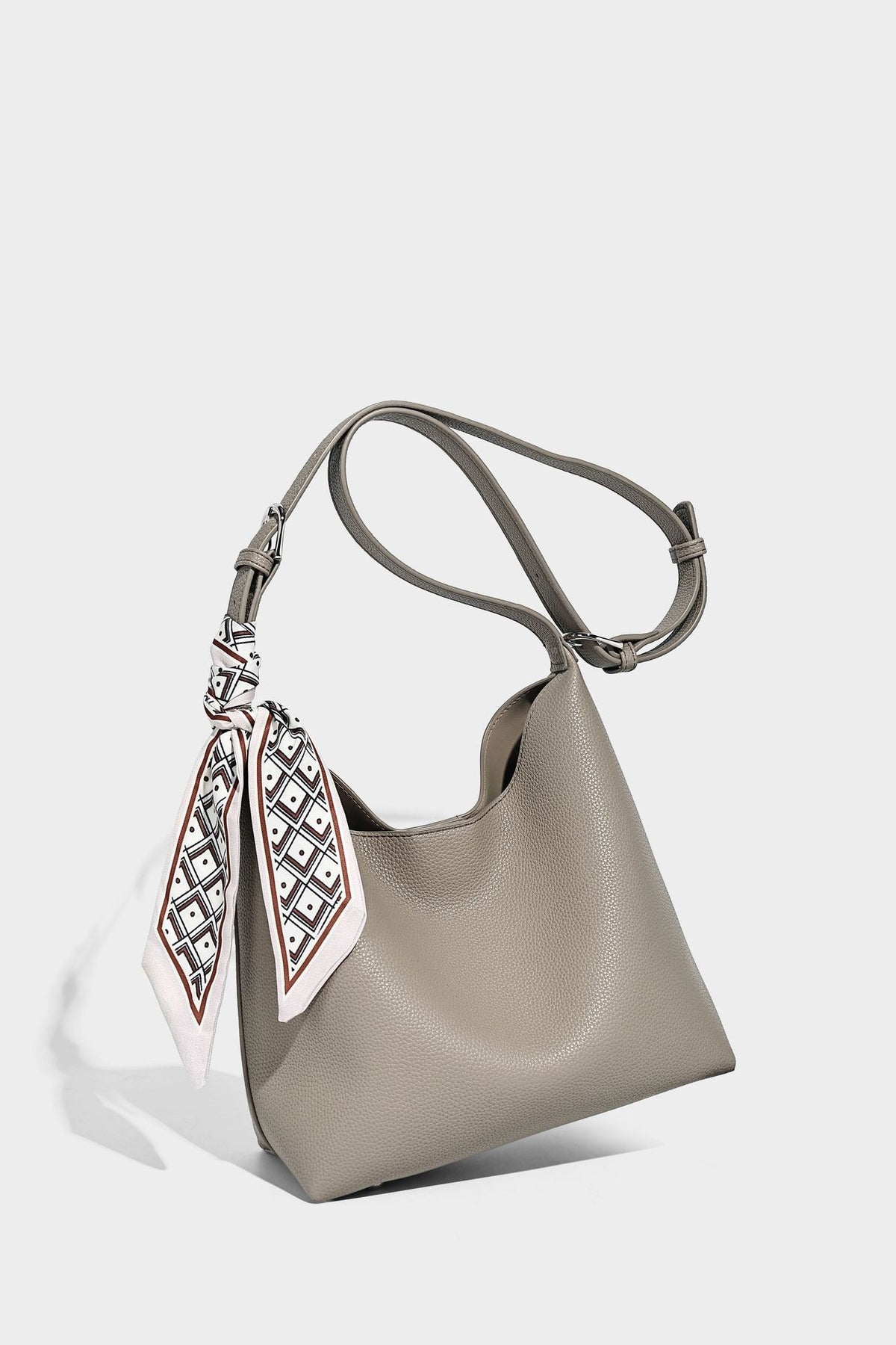 Soft slouchy hobo shoulder bag in pebbled matte finish with slim strap, silver-tone ring hardware, and knotted printed scarf