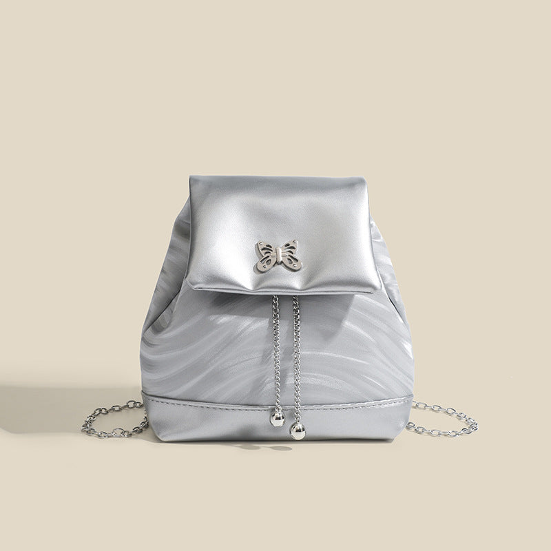 Compact ripple-embossed leather-look backpack handbag with silver butterfly clasp and chain straps, detail view 7