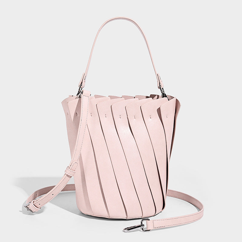 Structured pleated-panel bucket bag with curved top handle and detachable adjustable shoulder strap in smooth matte, front