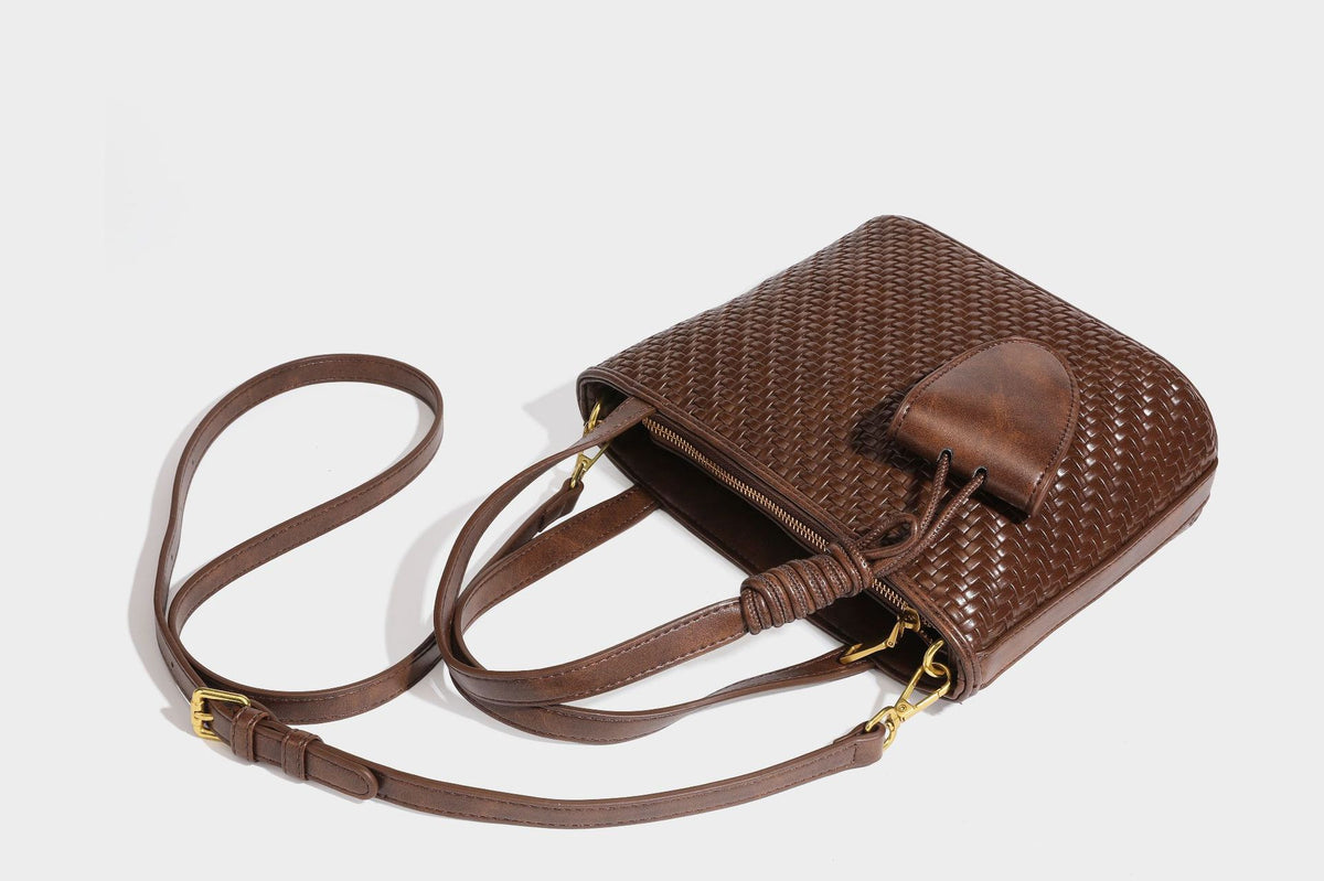 Strukturierte Tote Bag mit gewebter Oberfläche in Braun, goldfarbenen Metalldetails, seilumwickelten Tragegriffen, einer kleinen Fronttasche und weiteren Details